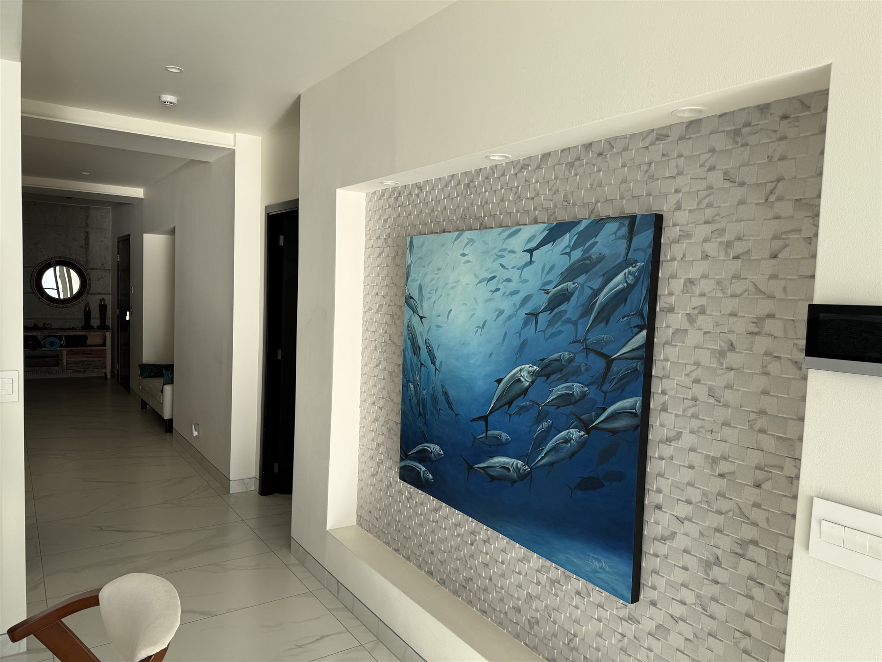 Blue fish artwork displayed in a recessed stone feature wall